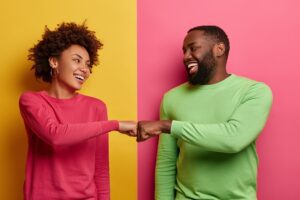 Mulher negra e homem negro sorrindo e conversando sobre o universo do infoprodutor